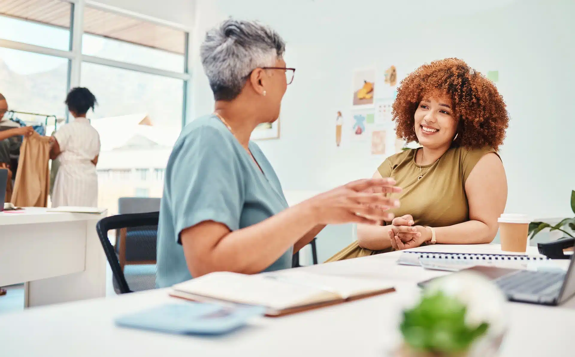 Deux collègues qui échangent au travail en souriant